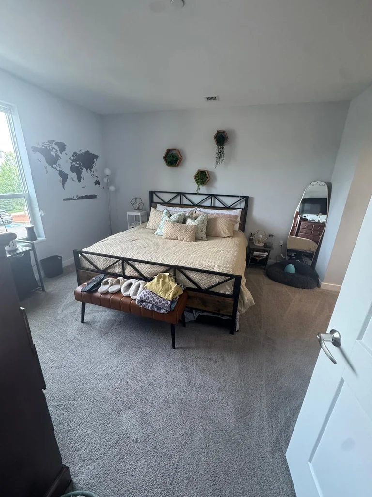 Bedroom after cleaning, bed made and carpet freshly vacuumed